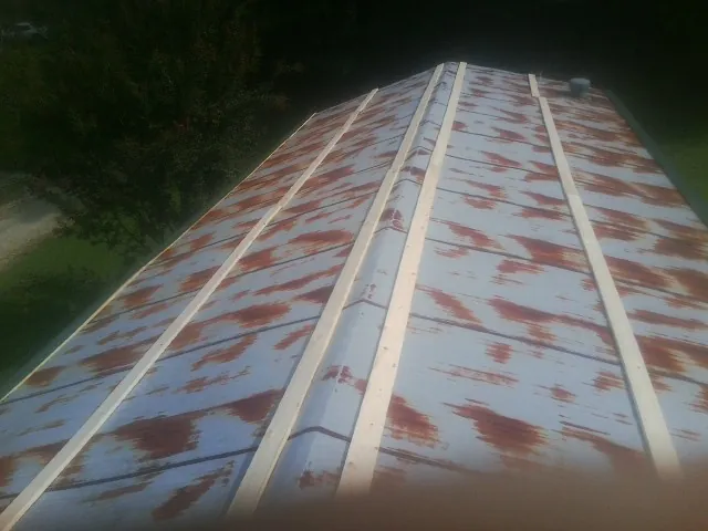 Rusted metal roof panels with new wood purlins before replacement — Storm Damage Roof Repair in Lakeview by Roofing Brothers